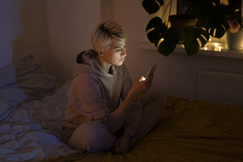 young adult looking concerned while checking finances on their phone