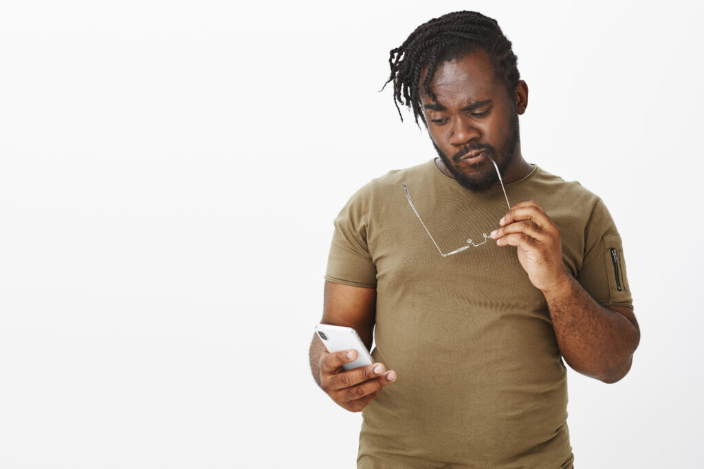person shocked at falling crypto prices on phone screen

